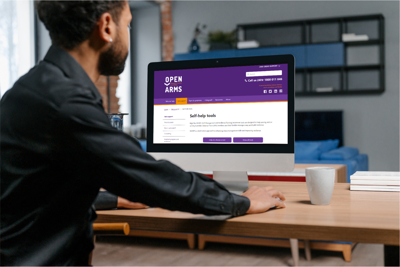 Man looking at self-help section of Open Arms website on computer.