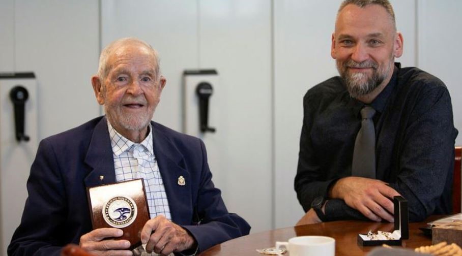 A young man and older man smile for the camera