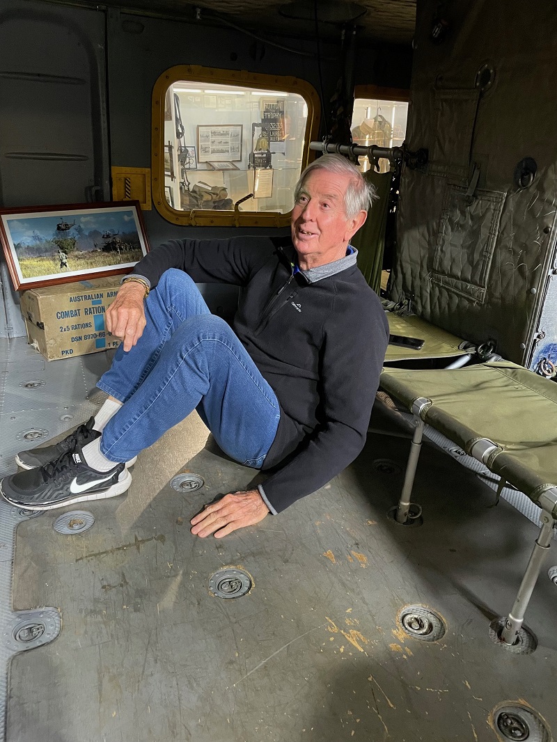 Older man sits on floor of old helicopter
