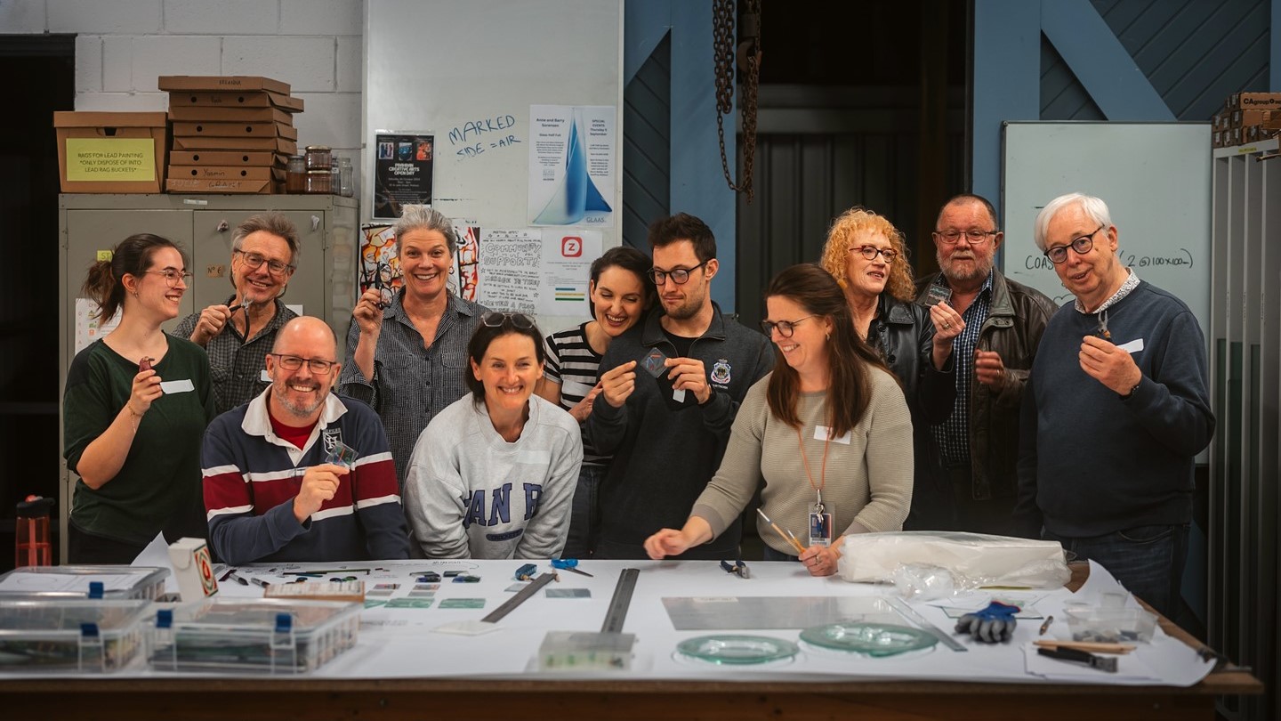  FOVA25 team and workshop leaders participating in a celebratory glass workshop at Glass Works.