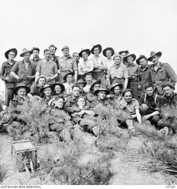 Black and white photo of about 20 soldiers posing for camera