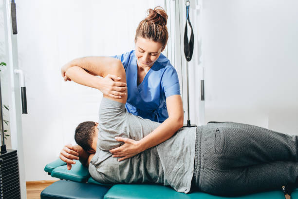 female physiotherapist providing arm stretching support to a male patient