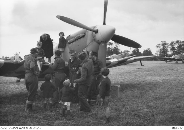 Black and white photo of a Spitfire aircraft, with a pilot and children congregated around it.