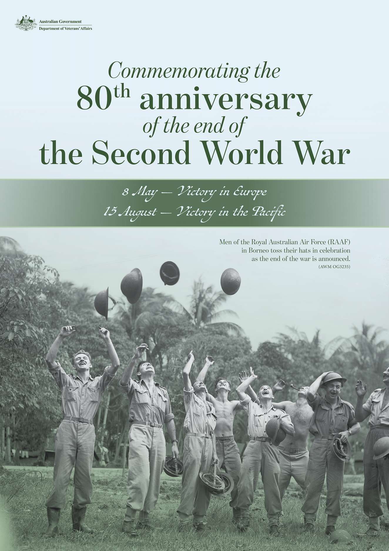 Black and white photo of soldiers throwing their helmets in the air in celebration