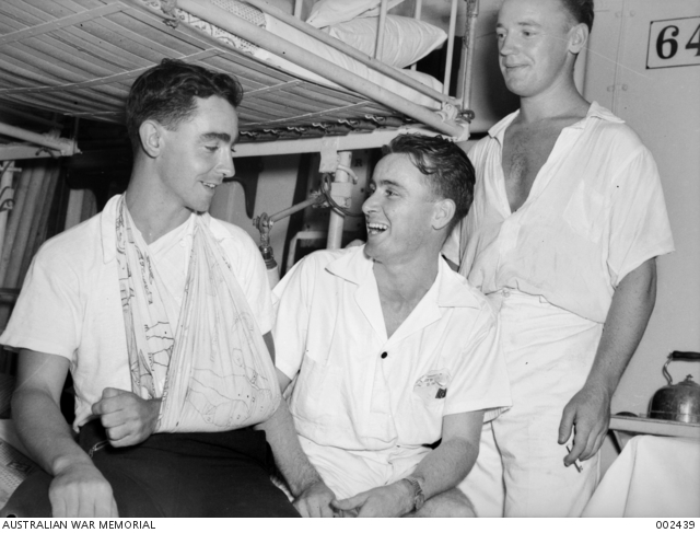 A black and white photo of three sailors, one with his arm in a sling