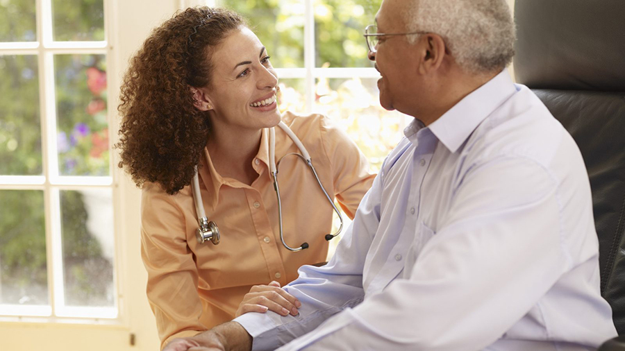 Elderly patient being attended to by nurse or doctor.