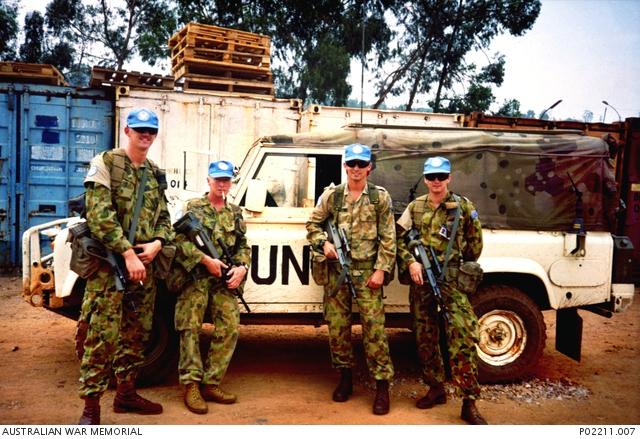 A photo of Australian peacekeepers standing in front of their Landrover.