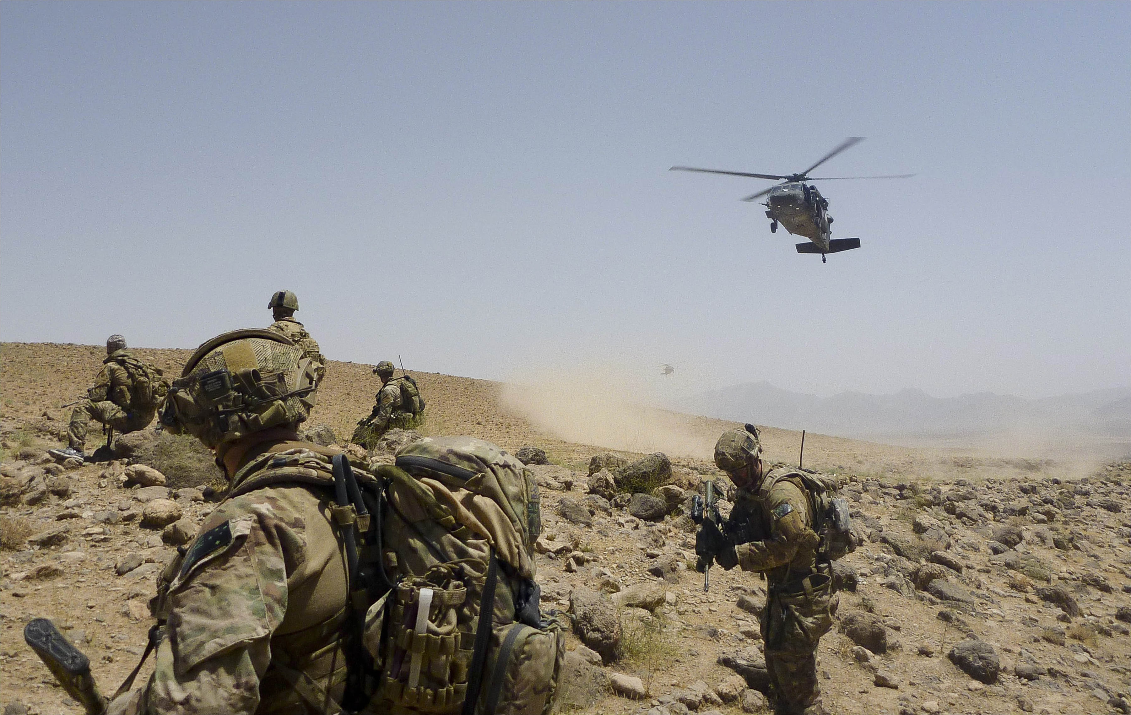 Australian Army soldiers prepare to be extracted by a US Army Black Hawk helicopter.