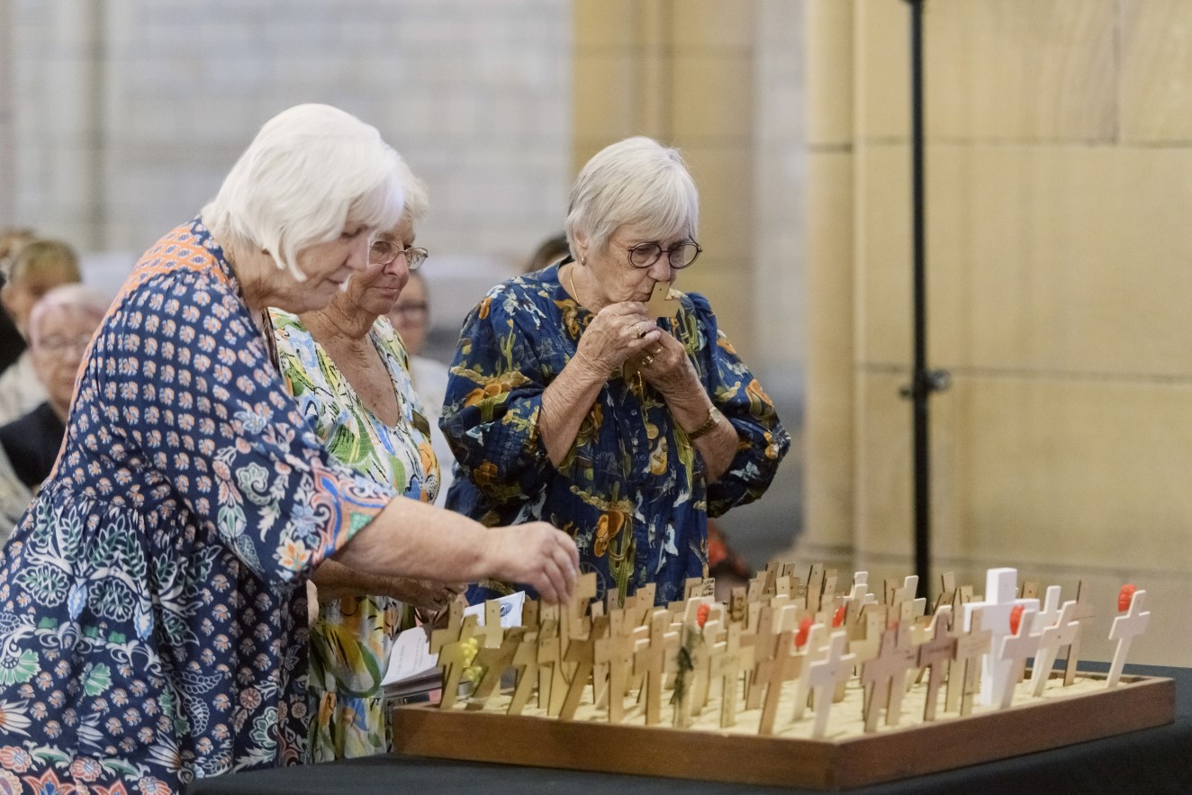 War widows from Redcliffe place crosses in memory of loved ones at a Field of Remembrance service. 