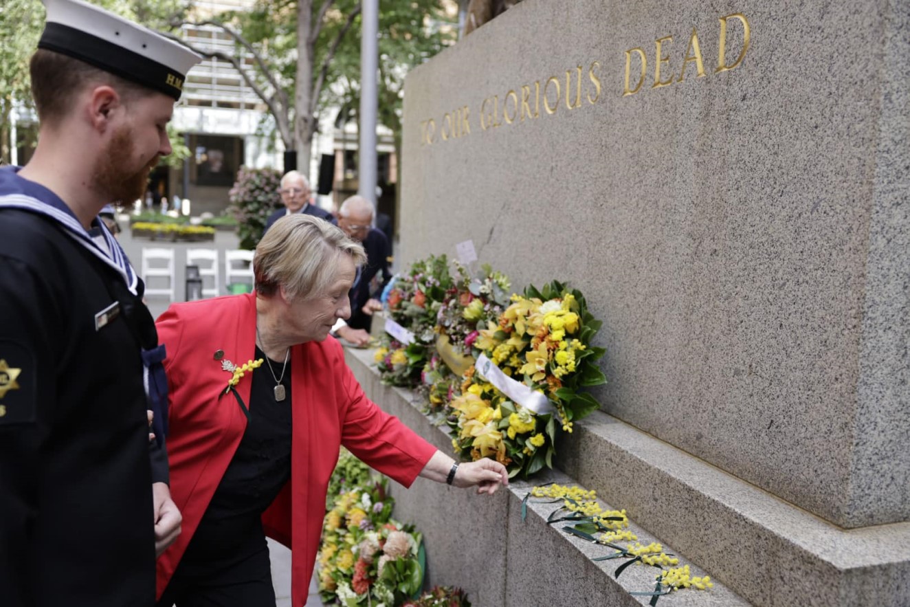 Widows Guild member Sue Doolin lays a branch of wattle at the War Widows Day 2025 Service in Sydney.