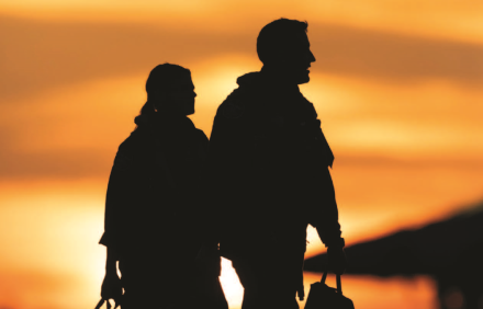 Two air crew personnel silhouetted against setting sun