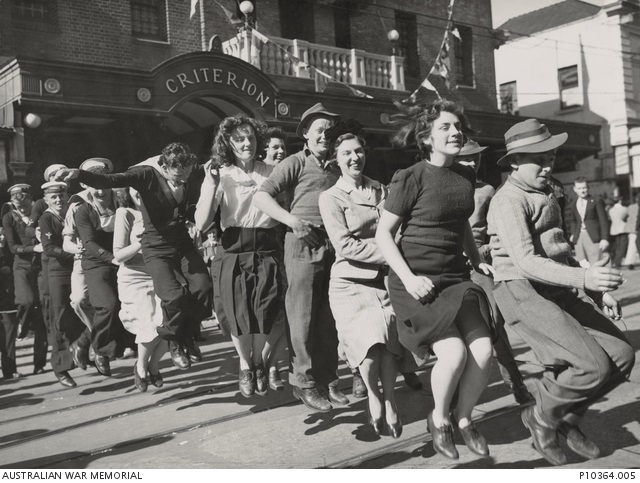 Crowds of civilians and soldiers fill a Sydney city street during celebrations for VP Day.