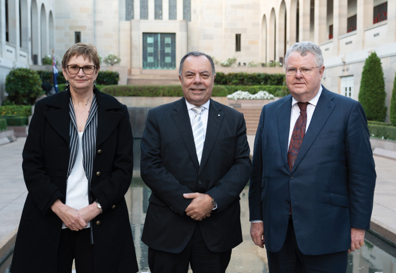                         Royal Commissioners Dr Peggy Brown AO, Nick Kaldas APM and the Hon James Douglas KC photographed in front of the Pool of Reflection at the Australian War Memorial.