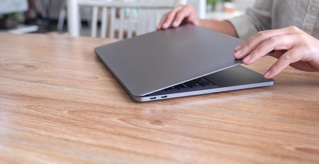 Close up image, hands closing a laptop