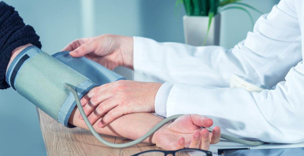 Doctor taking blood pressure of patient, just hands and arms showing