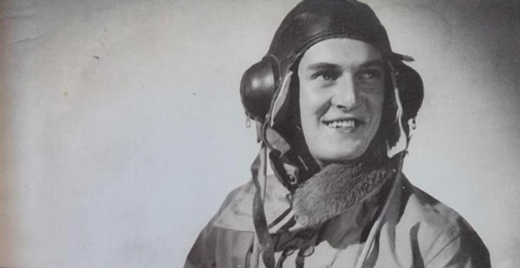 Black and white photo of smiling young man in flight gear