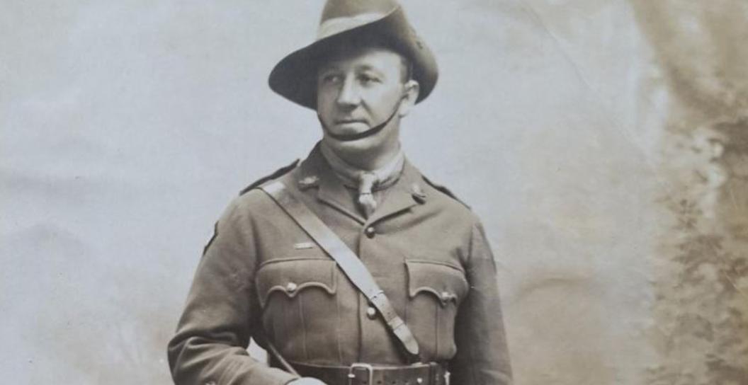 Black and white studio photo of man wearing officer's uniform