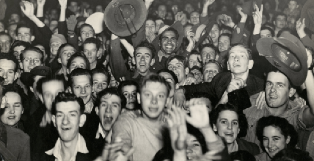 A crowd of civilians and service personnel celebrate VP Day on the streets of Brisbane, 15 August 1945.