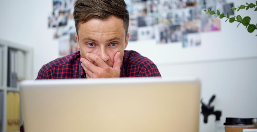 Man looking shocked at information on his computer