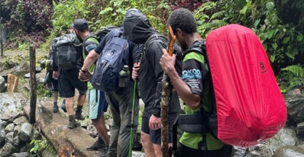 Veterans and Papua New Guinean local porters hiking the Kokoda Track
