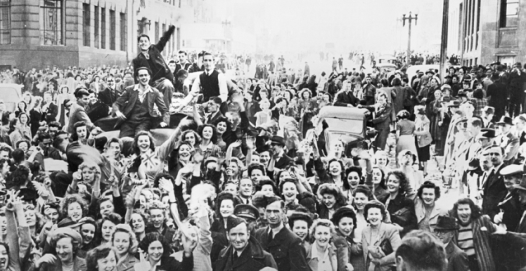 Crowds of civilians and soldiers fill a Sydney city street celebrating VP day.