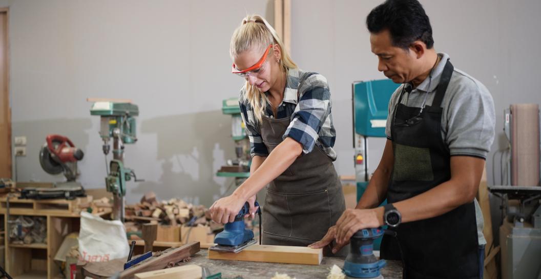 Teacher showing student how to use woodworking tools