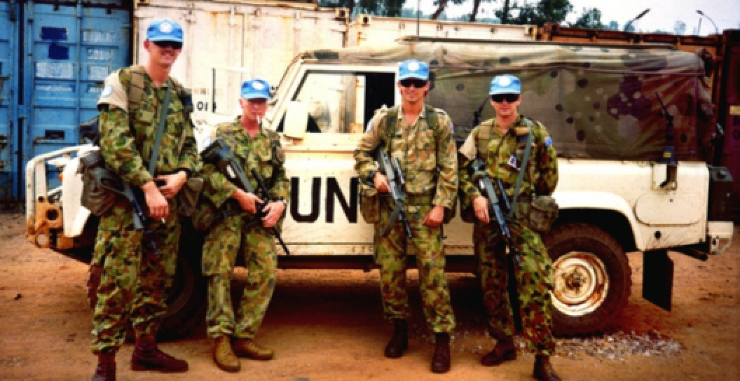 A photo of Australian peacekeepers standing in front of their Landrover.