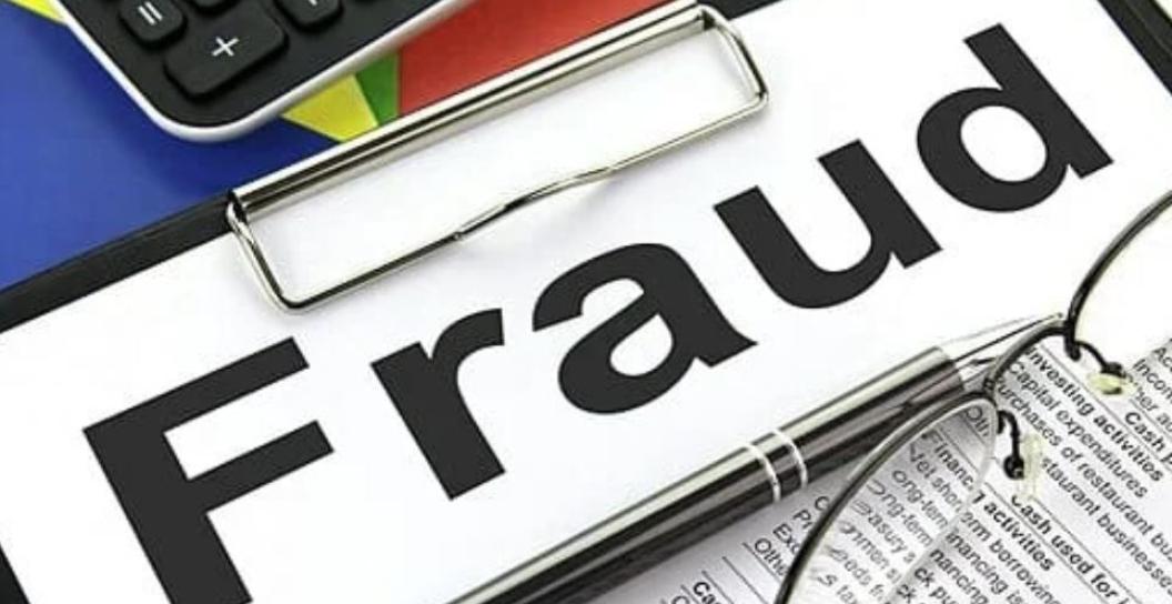 Fraud written on a clip board with a calculator in the background