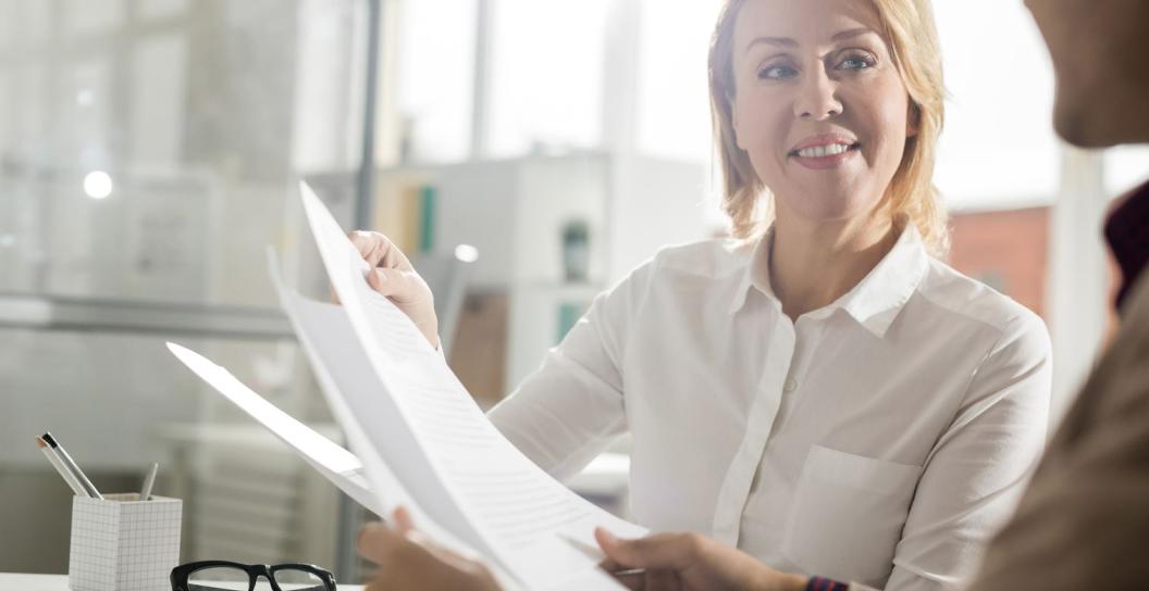 A person helping another person with paperwork