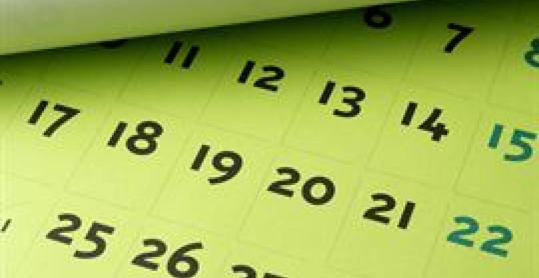 Image of a dates written in black ink on a green post-it note.