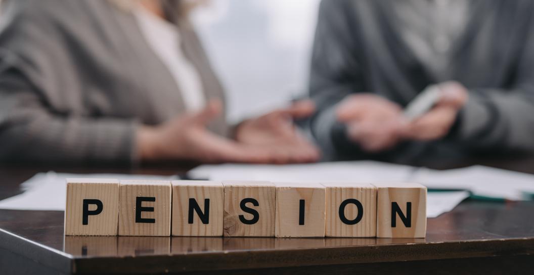 Pension written on wooden blocks with people in background