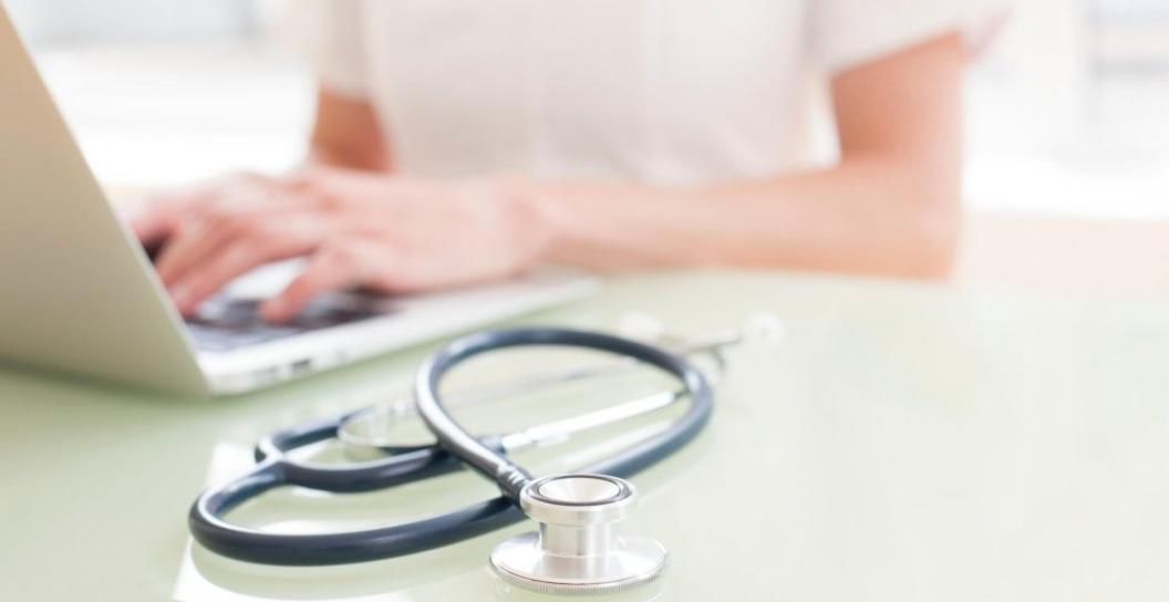 Doctor on computer with stethoscope 
