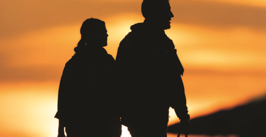 Two air defence crew personnel silhouetted against the setting sun