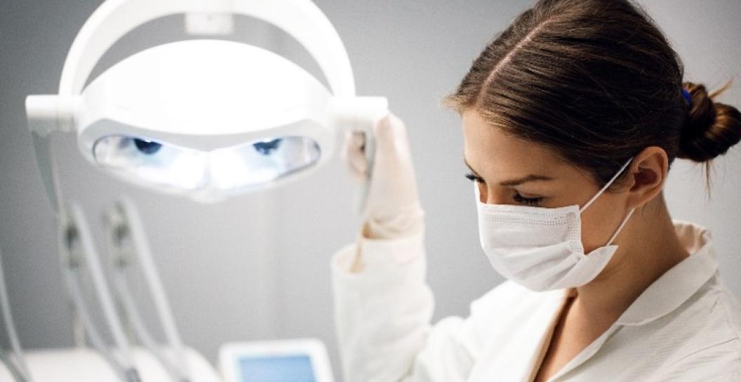 Medical officer angles a light downwards