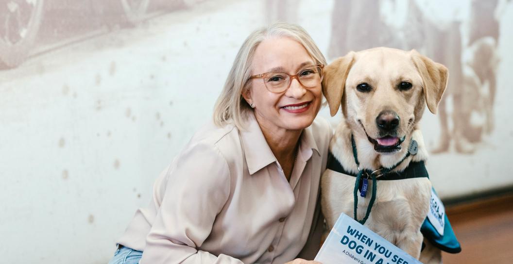 Female veteran with assistance dog holding a book