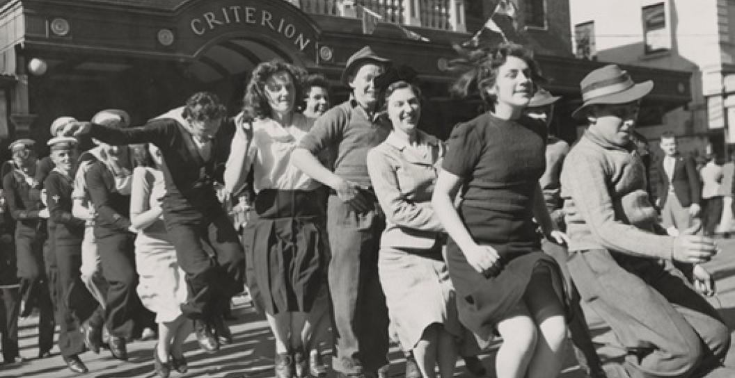 Crowds of civilians and soldiers fill a Sydney city street during celebrations for VP Day.