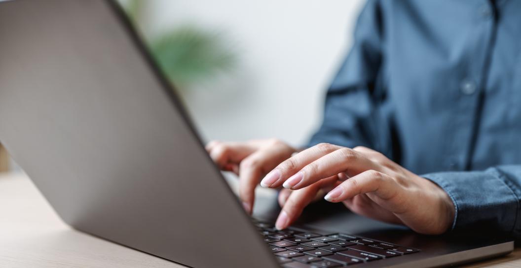 Man types on laptop
