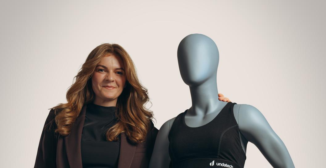 Woman stands next to mannequin