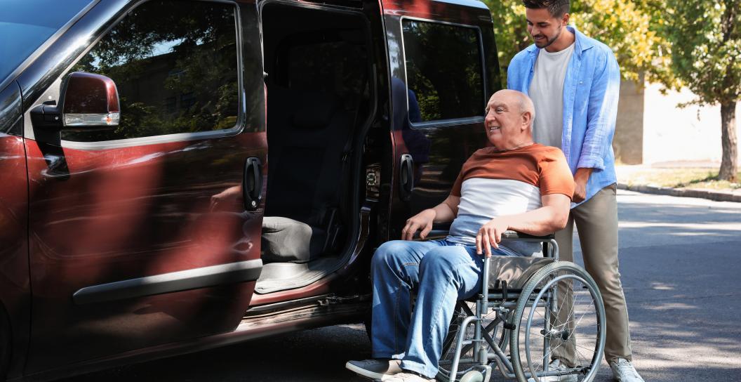 Man helping senior get into vehicle