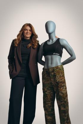 Woman stands next to mannequin